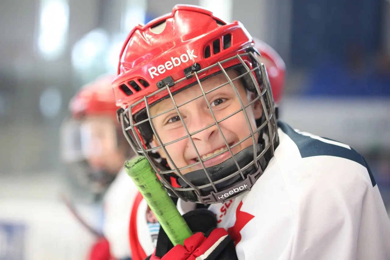 Ung ishockeyspiller med rød hjelm